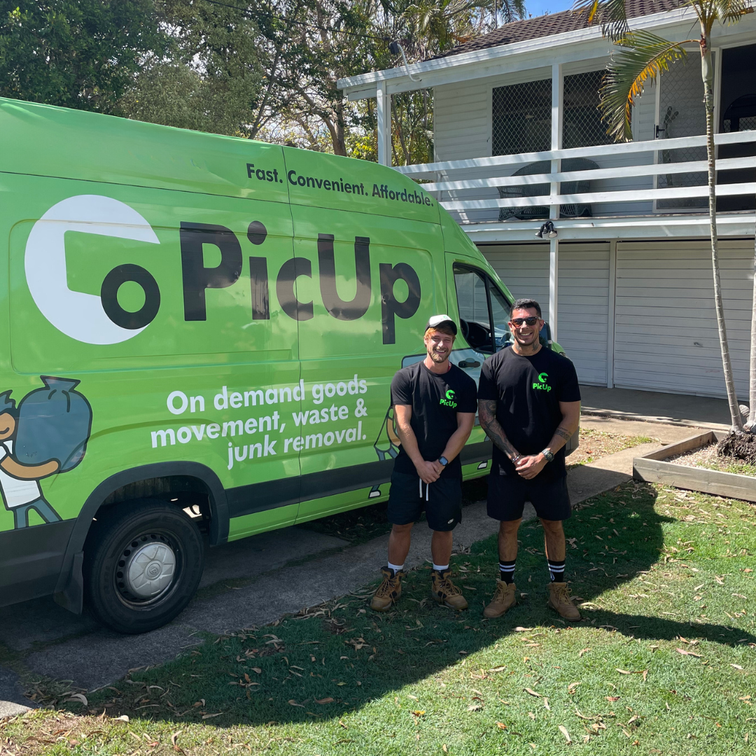 A PicUp driver and offsider standing beside a branded green PicUp van outside a house